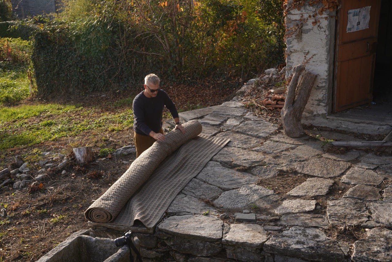 Martin Gabriel - Outdoor Teppich Modell Bronze Kupfer wird zusammen gerollt auf einer Stein-terrasse