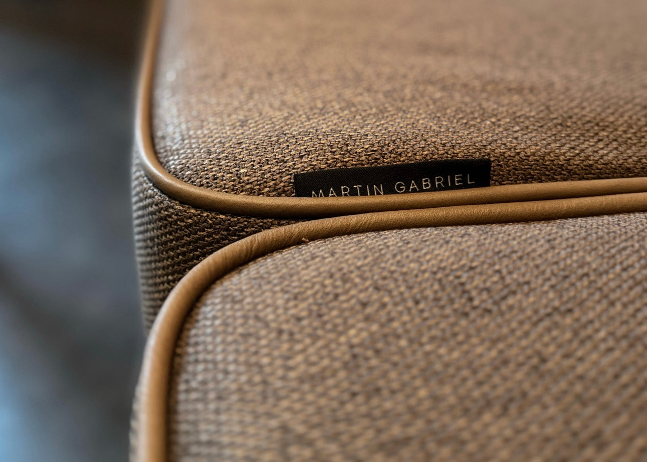 Nahaufnahme des Sofas in The Bar im The Chedi Andermatt mit neuem Schaumstoff, präzisem Keder, hochwertigem Textilbezug und sichtbarem Martin-Gabriel-Logo.