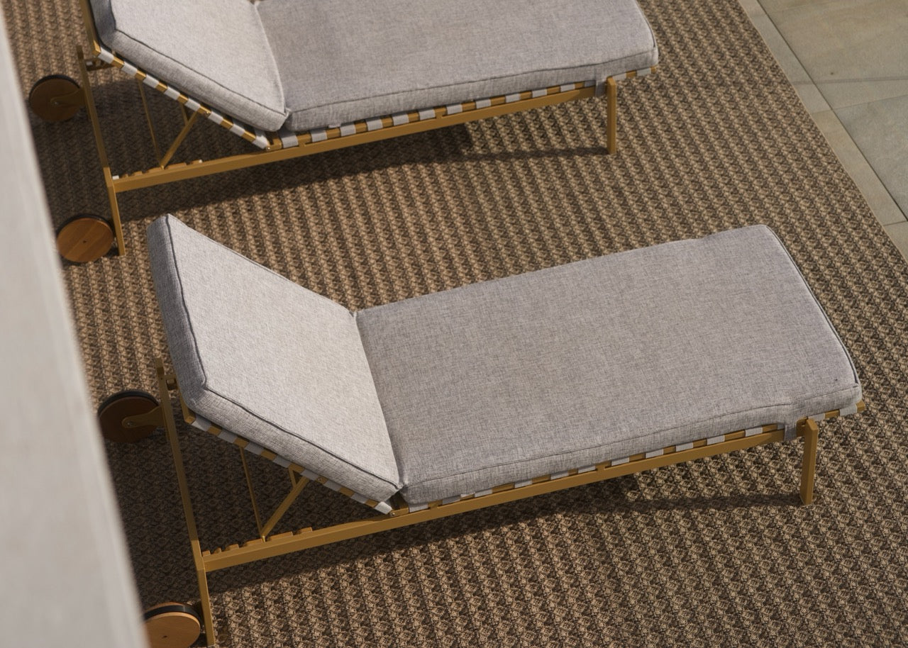 Outdoor-Teppich in natürlicher struktur unter zwei modernen Sonnenliegen auf einer Terrasse.