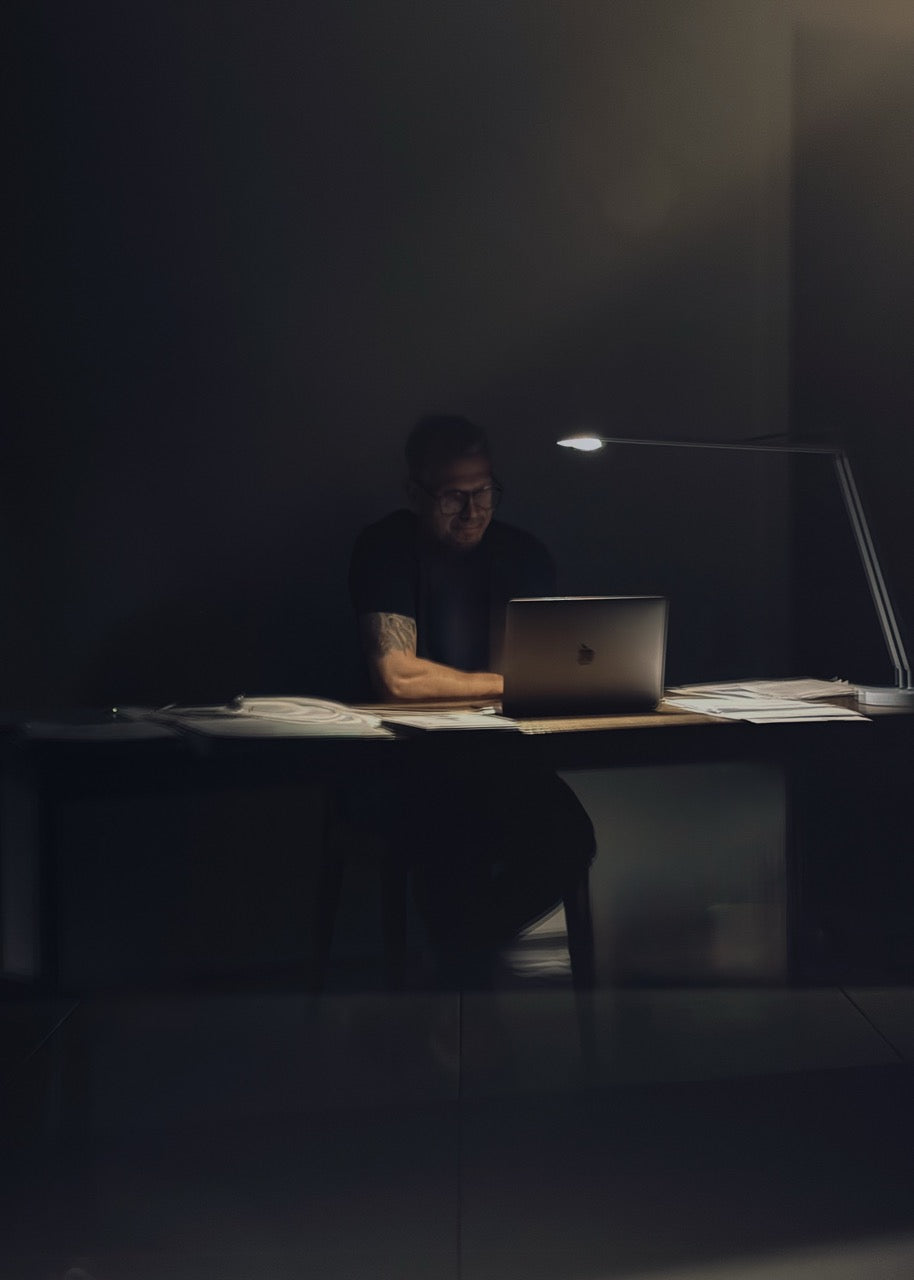 martin gabriel sitzt am schreibtisch nachts und arbeite am lap top 