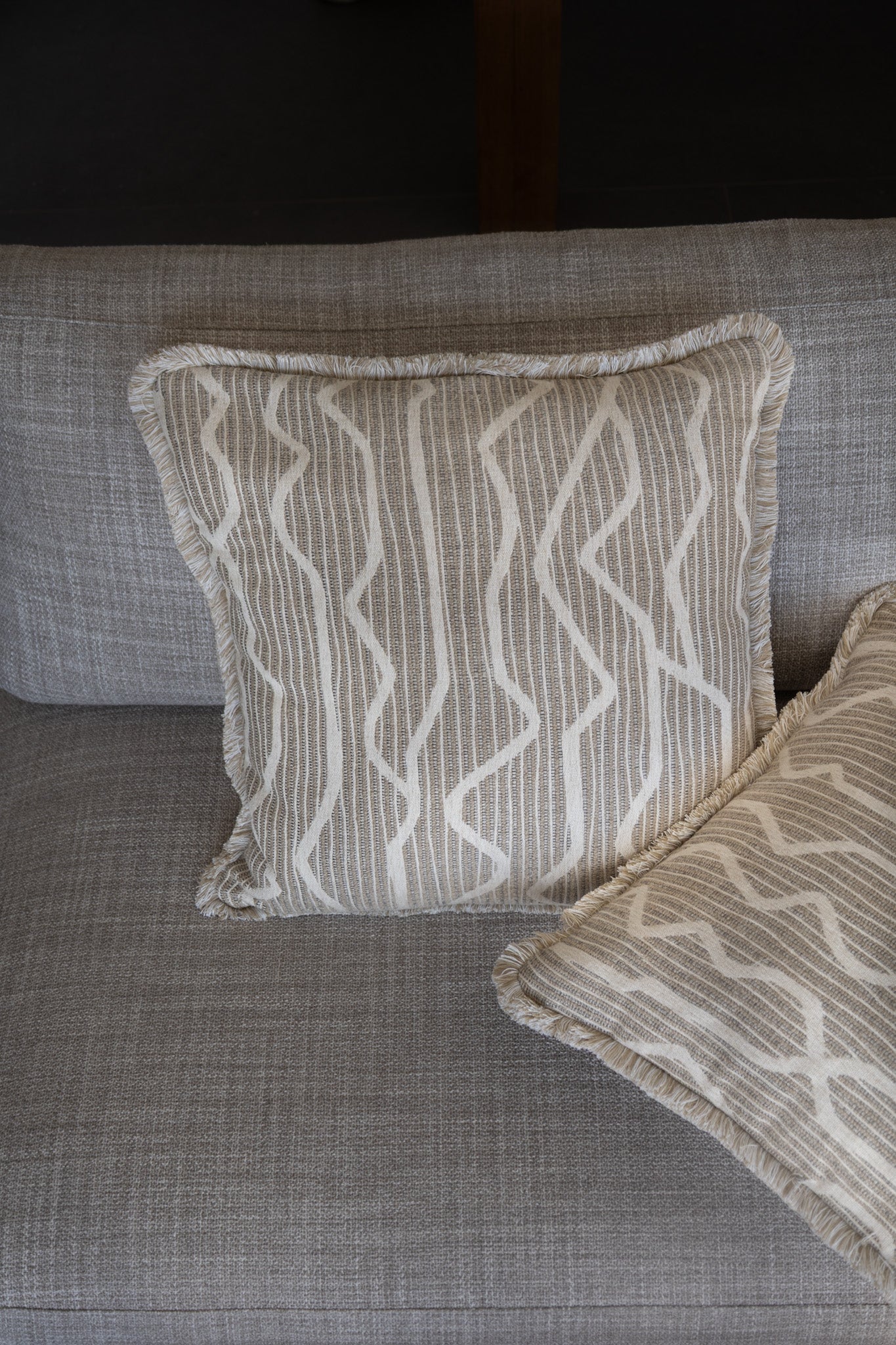 Zwei kissen von Martion Gabriel auf sofa modell linea beige mit struktur und auf sofa liegend 