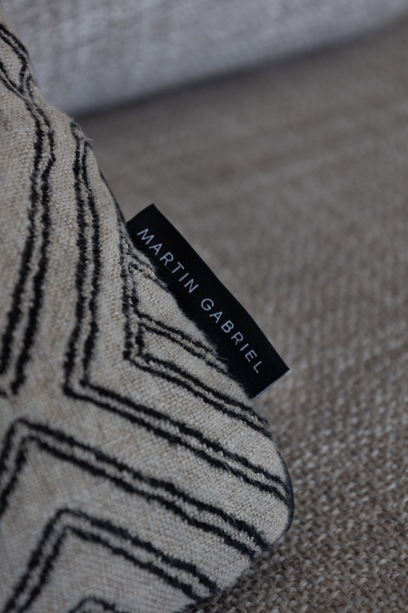 Martin gabreil Dekokissen modell npir labyrinth nahaufnahme ecke kissen mit label am kissen martin gabriel auf sofa 