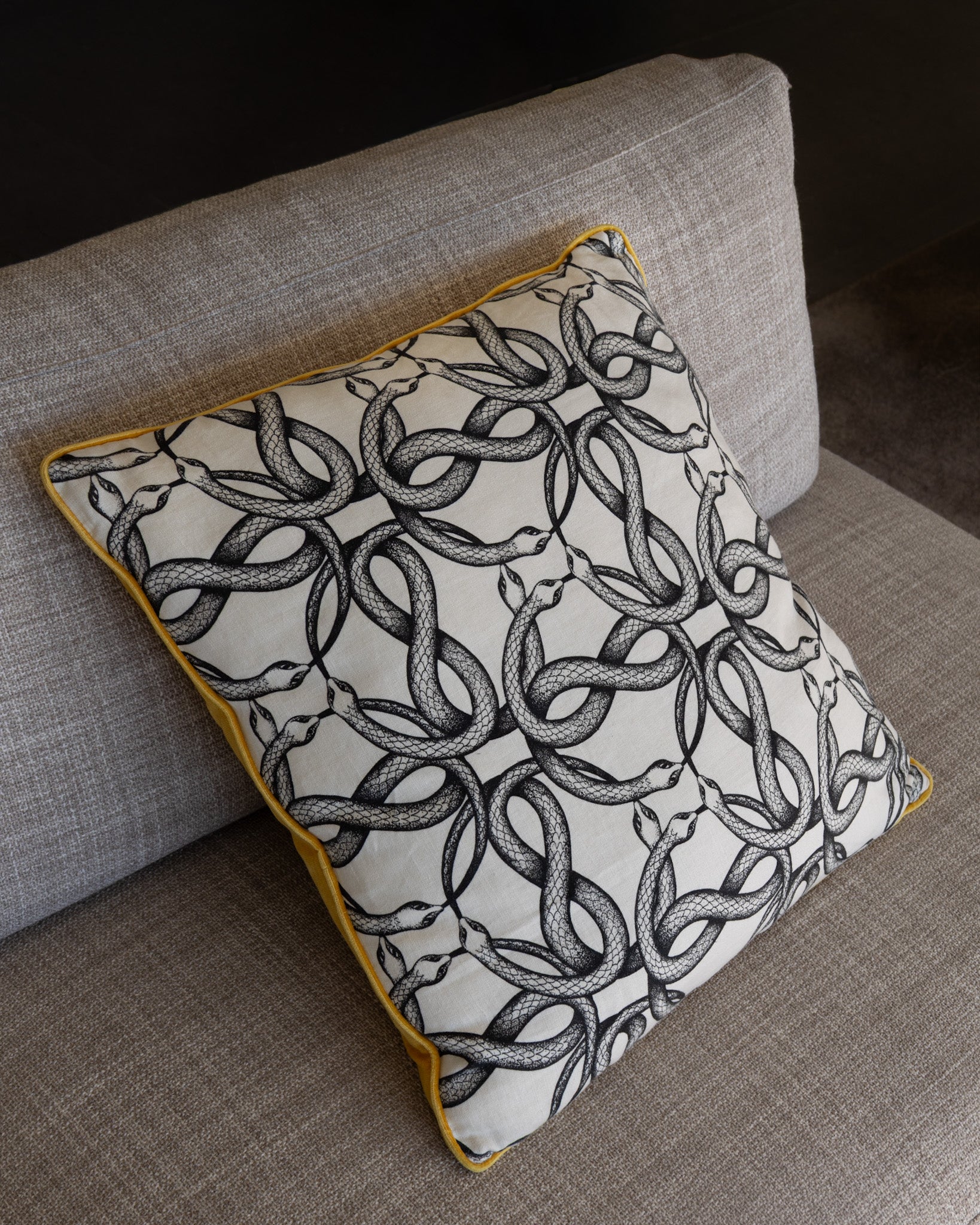 Serpent Noir Dekokissen 60x60 von Martin-Gabriel mit Schlangenmotiv auf Sofa