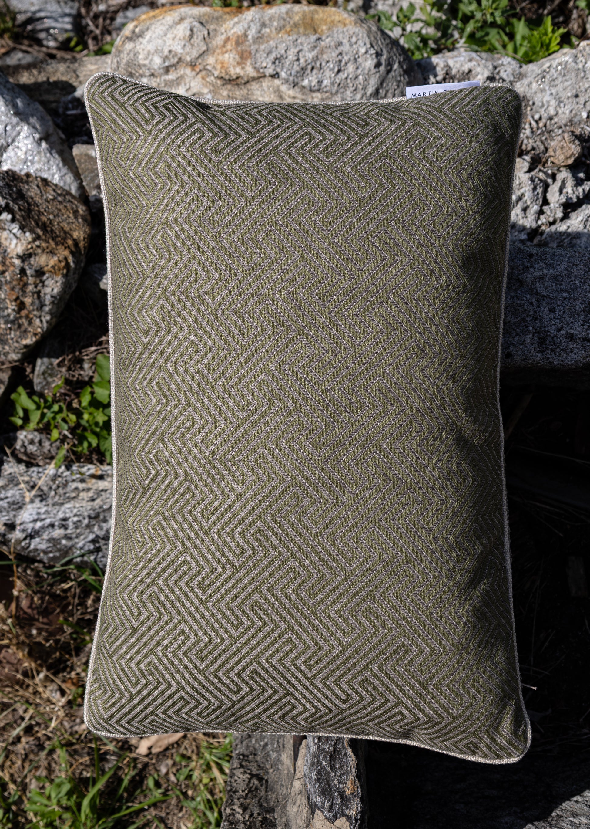 frontalaufnahme outdoorkissen in 40 x 60 cm auf steinen in grün