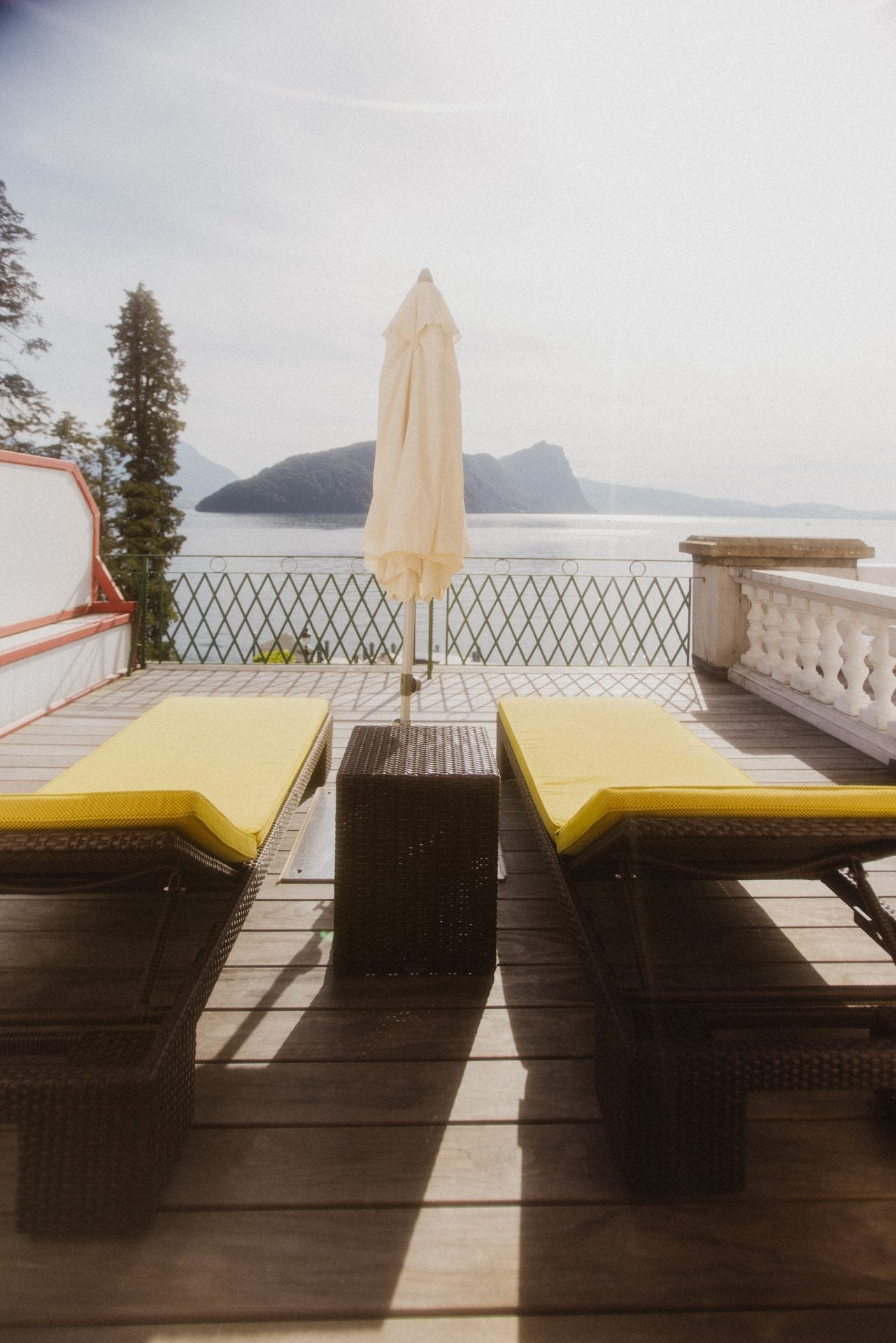 Gelbe Outdoor-Liegen mit hochwertigen Daybed-Polstern im Vitznauer Hof, mit Blick auf den Vierwaldstättersee.
