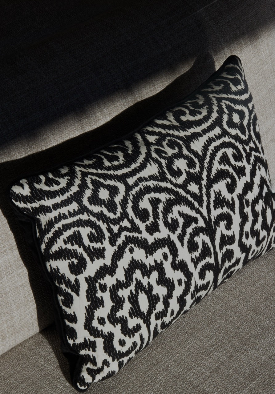 Martin Gabriel Designkissen Modell Relief Noir schwarz weisse relief struktur mit ornament muster auf sofa in grau seitliches foto perspektive 