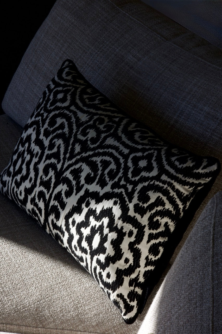 Martin Gabriel Designkissen Modell Relief Noir schwarz weisse relief struktur mit ornament muster auf sofa in grau mit schatten 