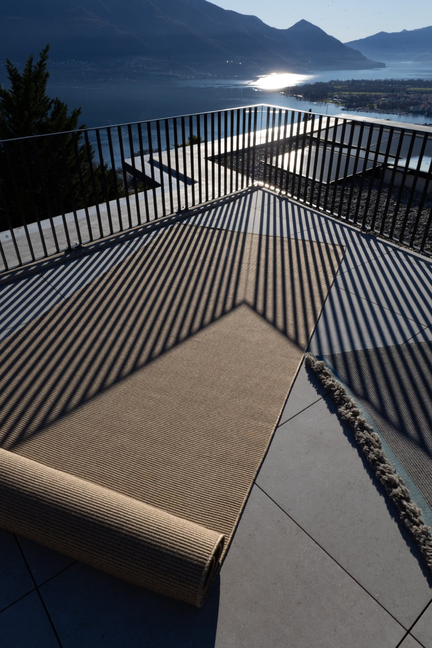Halbausgerollter Outdoor Teppich auf grosser Terasse mit schatten und seesicht 