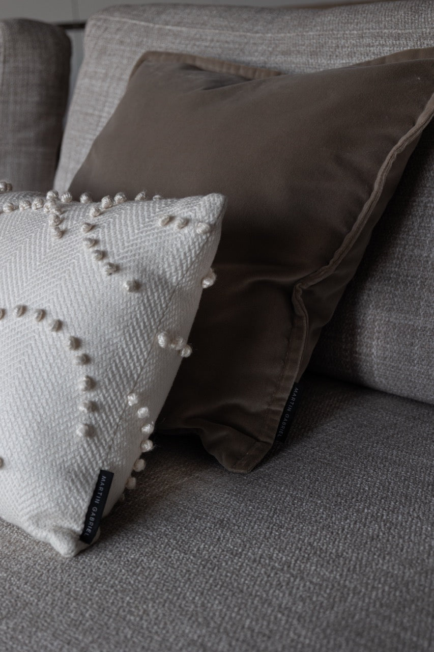 Martin Gabriel Dekokissen Soft relief white in weissem textil mit struktur und einem and beige farbenen velourkissen aus sofa in beige seitenansicht 