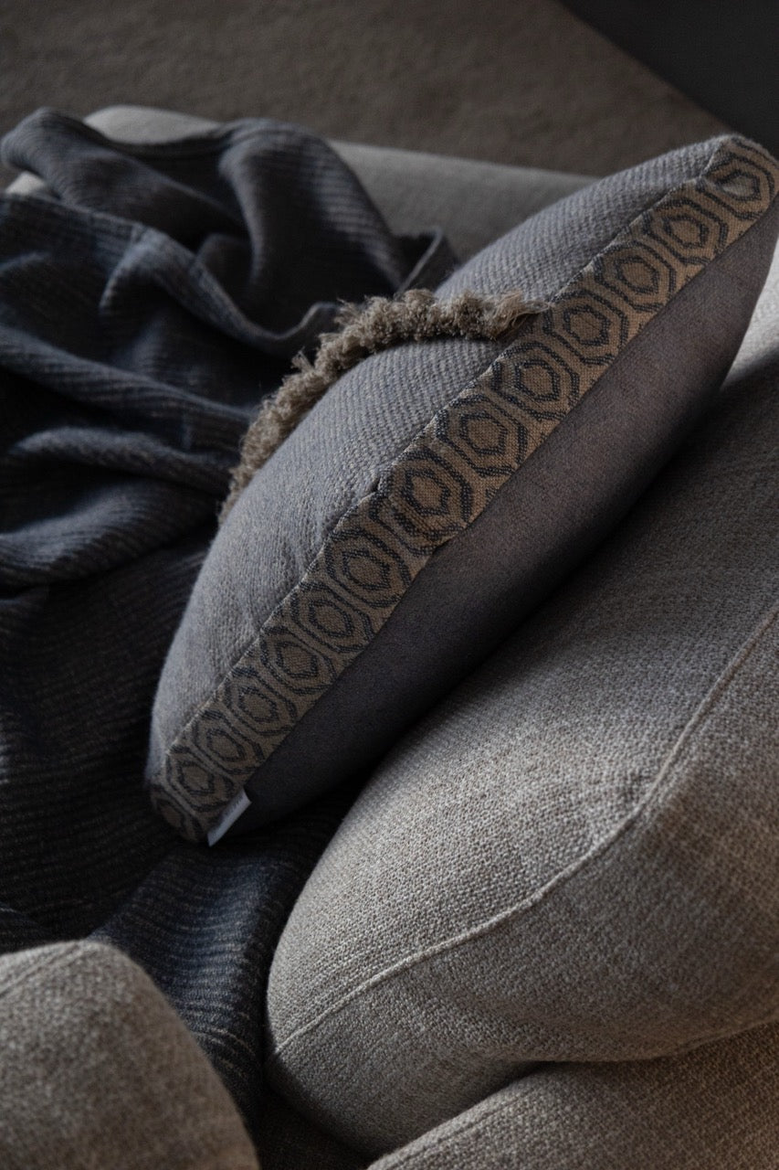 Martin Gabriel Leinen kissen auf sofa in blauem leinen mit fransen vertikal von oben ansicht mit bordüre in geometrischem design