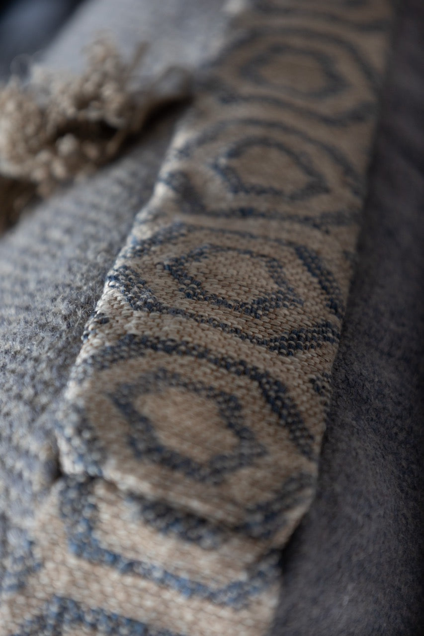 Martin Gabriel Leinen kissen auf sofa in blauem leinen mit fransen vertikal Detailansicht mit geometrischem Muster 