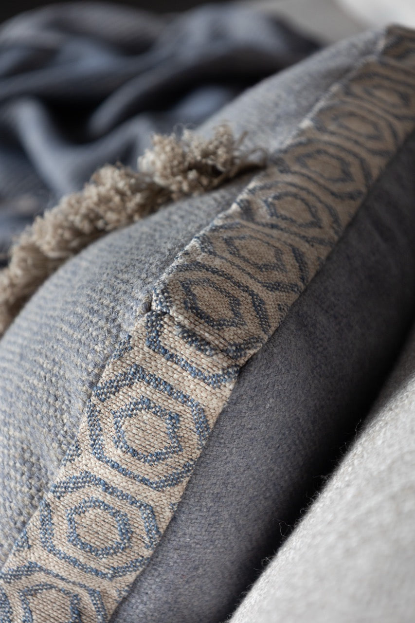 Martin Gabriel Leinen kissen auf sofa in blauem leinen mit fransen vertikal seitenansicht 