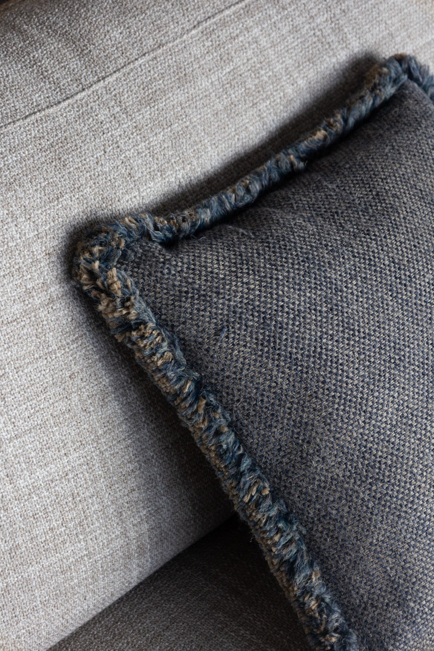 Martin Gabriel Leinen Kissen auf sofa mit blau beige farben und fransen ringsrum Seitenansicht