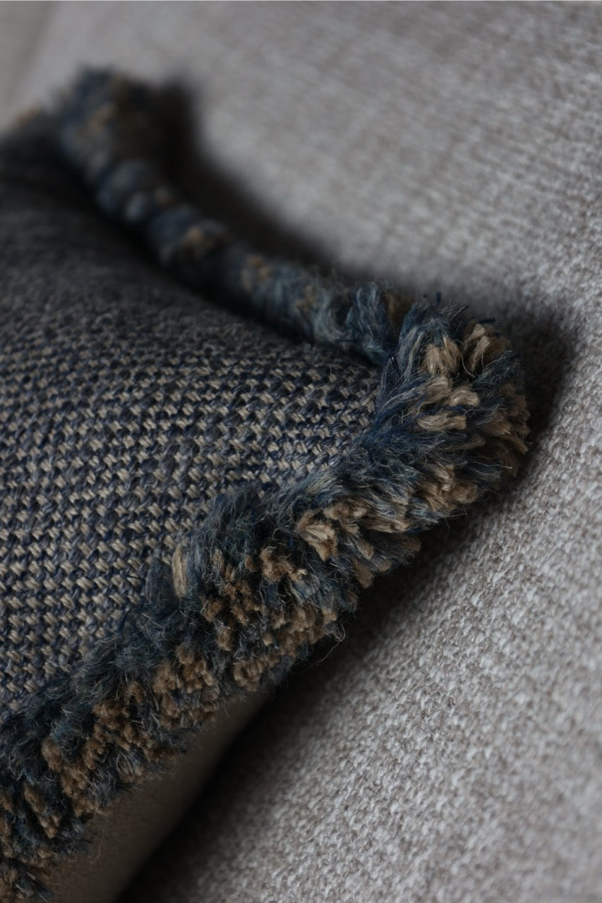 Martin Gabriel Leinen Kissen auf sofa mit blau beige farben und fransen ringsrum nahaufnahme struktur