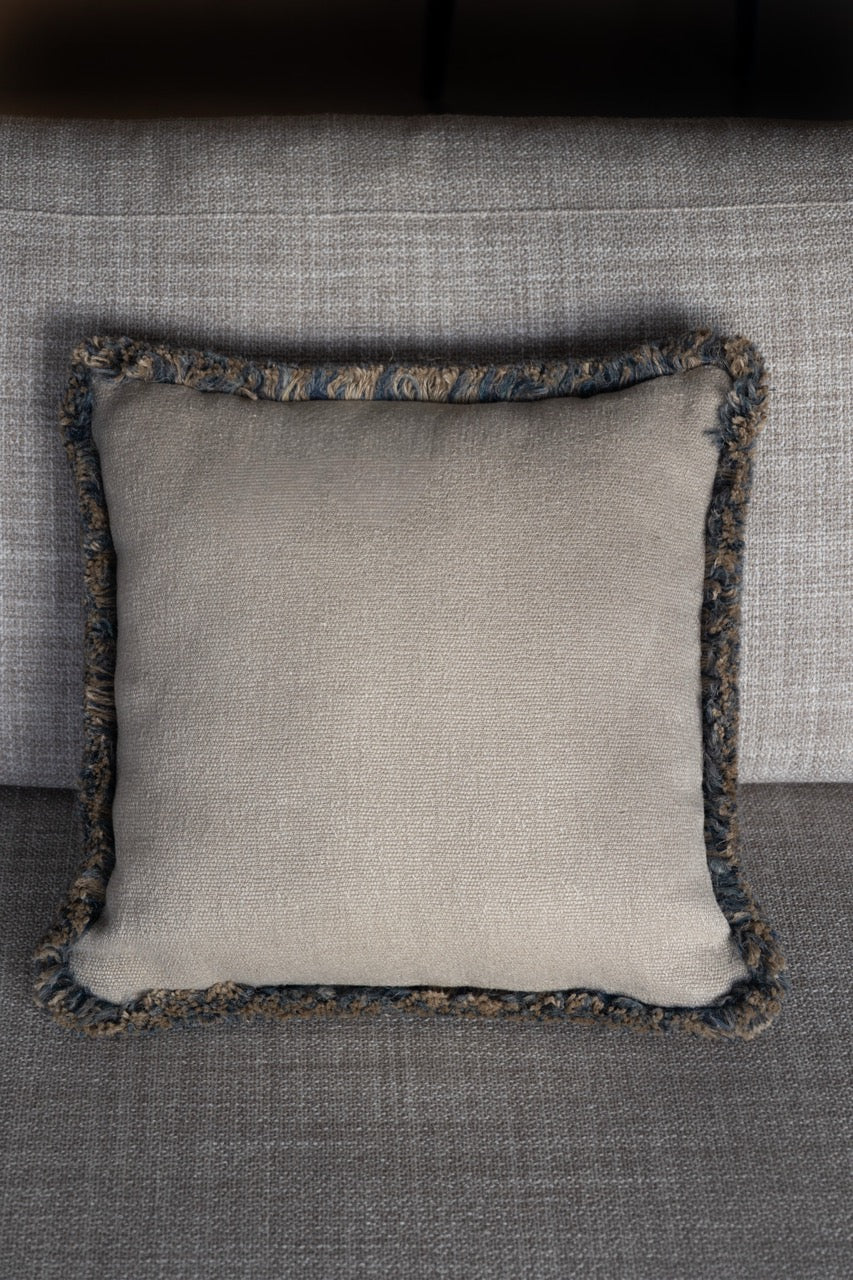 Martin Gabriel Leinen Kissen auf sofa mit blau beige farben und fransen ringsrum rückseite in sandfarbenen leinen