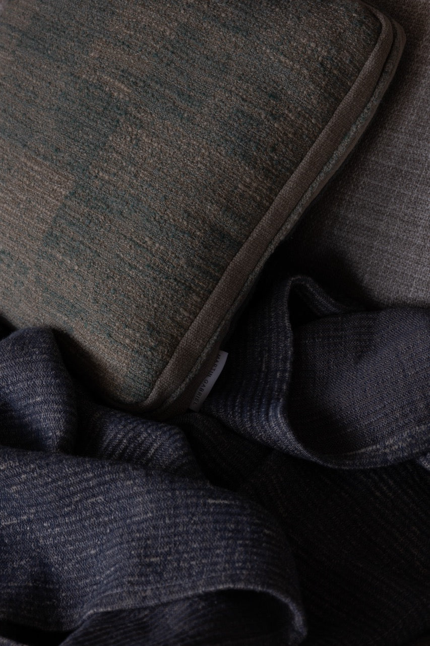 dekokissen leinen grün beieg mi struktur auf blauer wolldecke 