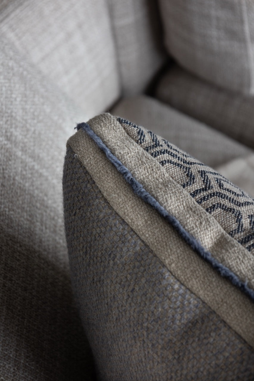 Martin Gabriel leinen kissen auf Sofa seitenasicht mit geometrischen Muster in blau und beige tönen von hinten sichtbar