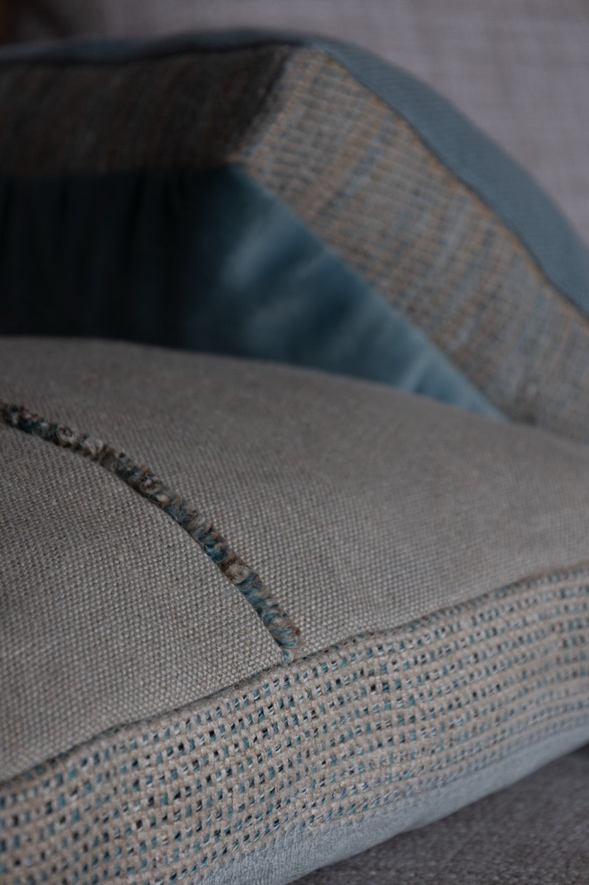 Martin-Gabriel Leinen Dekokissen Blue Ligne 02 mit Mittelband und feiner Fransenkante in Naturton und hellblauer Rückseite auf Sofa
zwei kissen zusammen 