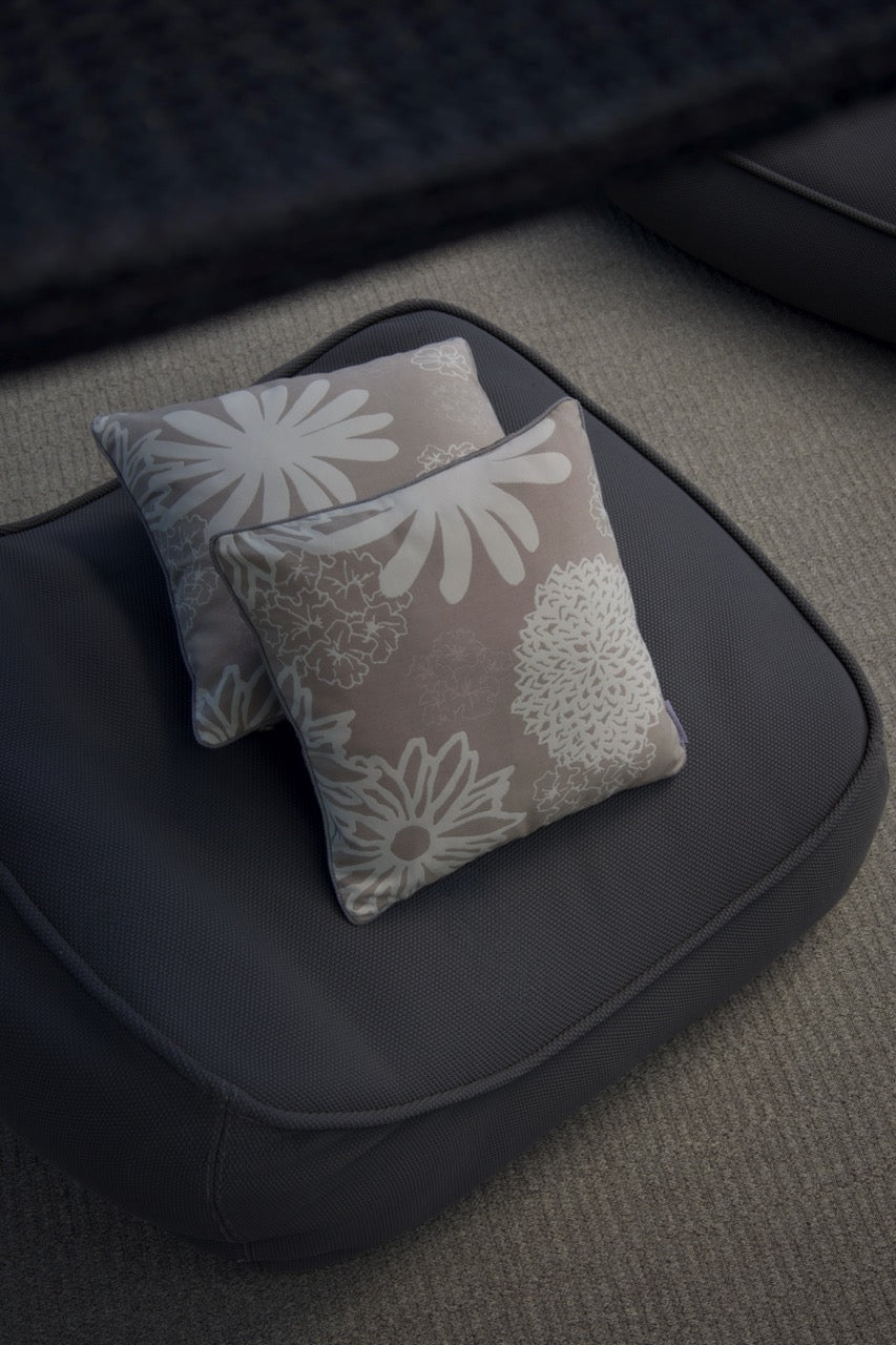 Zwei Outdoorkissen auf einem sessel mit floralmuster 