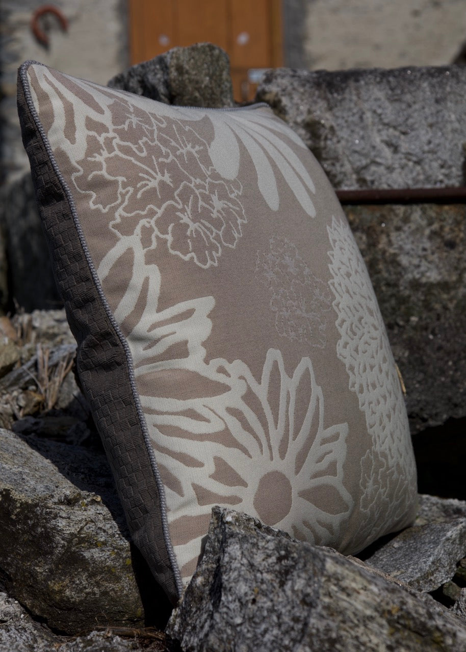 Outdoorkissen an Steinen gelehnt, in taupe beige floralmuster 