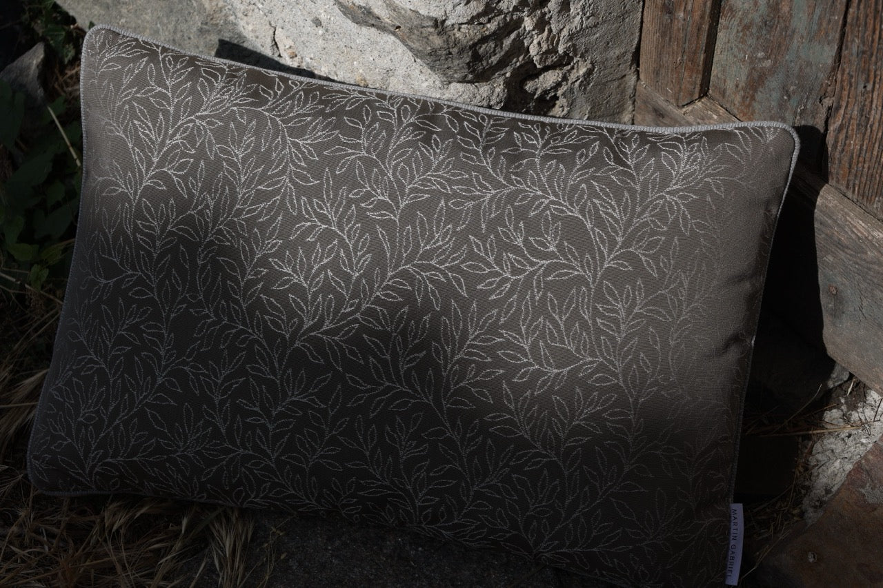 Outdoor Kissen mit blätter embroidered in braun taupe auf boden platziert an steinmauer