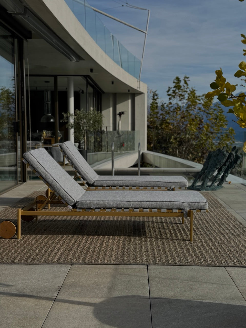 Outdoor Teppich Martin Gabriel auf grosser Terrasse  braun bronze struktur und darauf zwei sonnenliegen