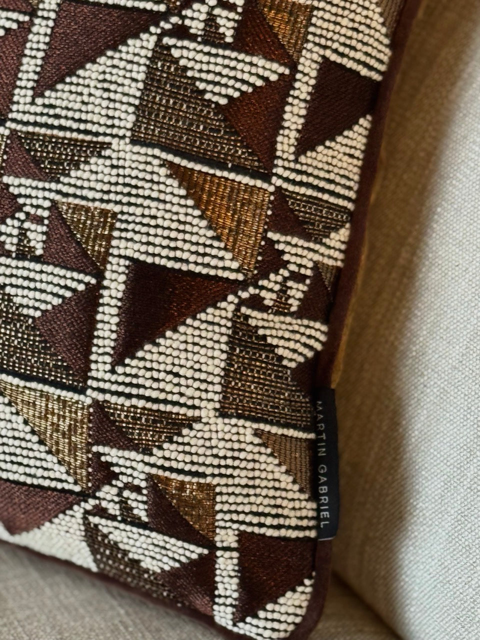 Martin Gabriel Designkissen modell geometrie detailbild mit geometrischen design und label sichtbar auf dem sofa 