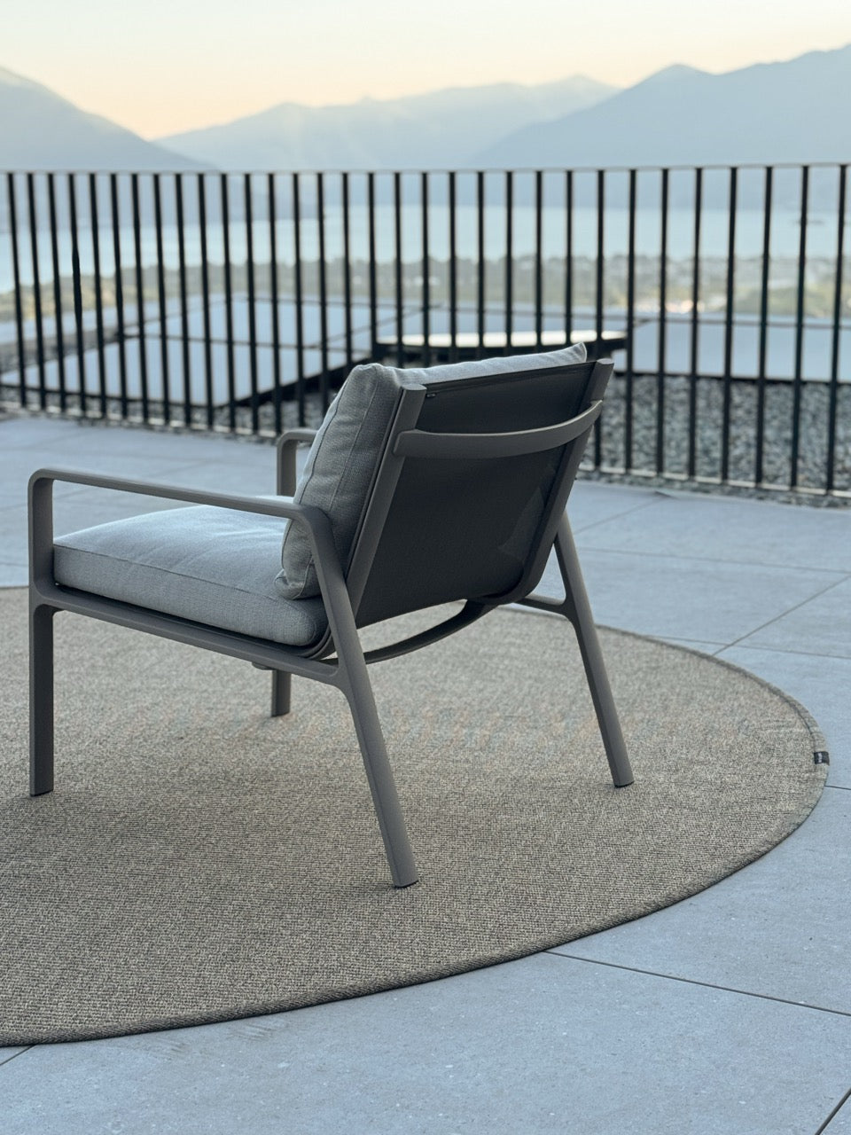 Grosser runder Outdoor teppich Taupe in feiner gewebter Struktur auf grosser Terrasse am See