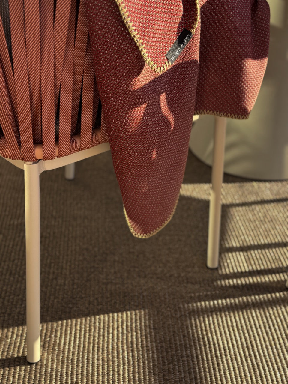 Detailaufnahme Outdoor Teppich mit gewebter Struktur und einem Stuhl und einer Outdoor Decke 