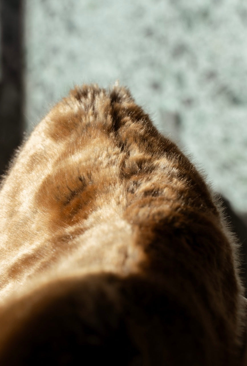 Seitenansciht des Kunstfellkissens Wiesel mit sichtbarer weicher Struktur.