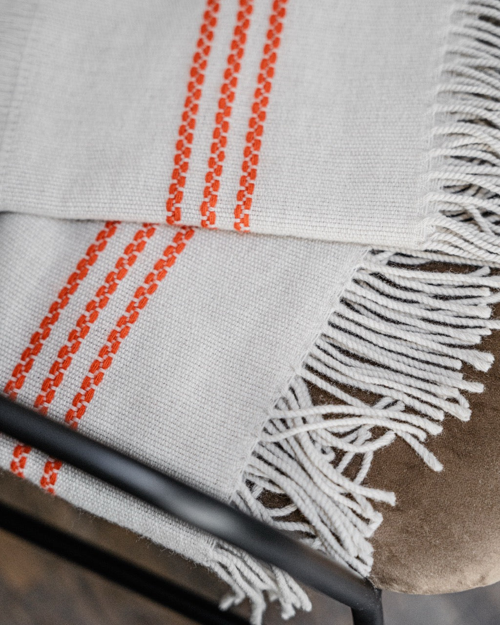 Martin Gabriel plaid modell ainu, detailfoto fransen und orangenen streifen auf einem stuhl