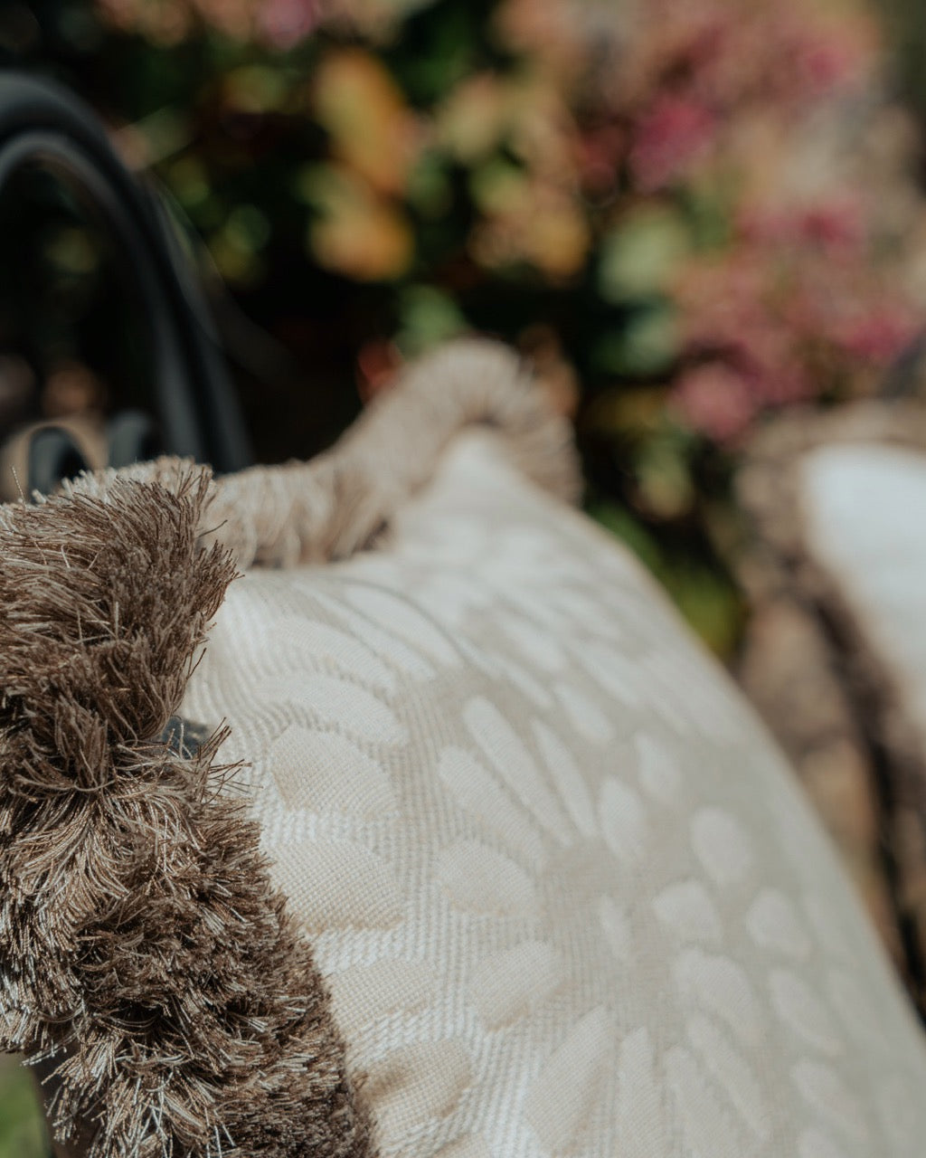Detailnsicht outdoor Kissen mit Fransen in Beige und Floralmuster 