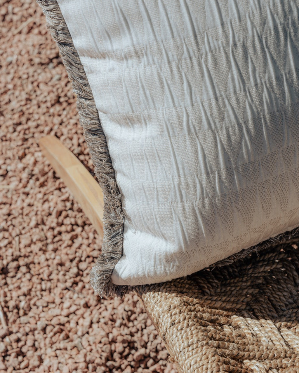 Detailansicht von hellem Outdoor Kissen mit Fransen mit struktur 