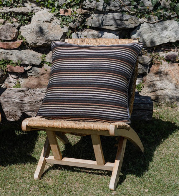 Outdoor Kissen in schwarz mit dezenten patellfarbenen Streifen auf Sessel auf einer Terrasse 