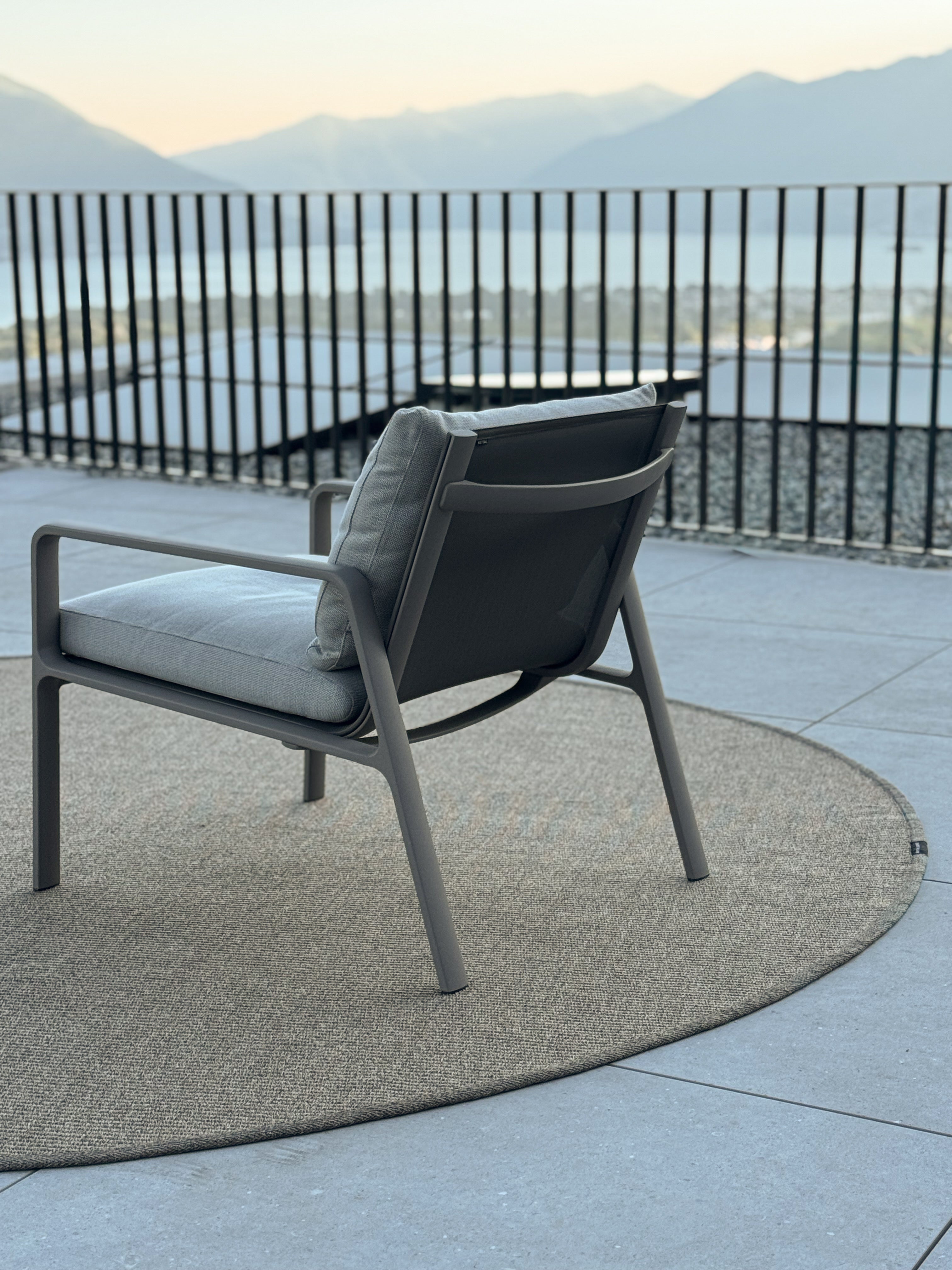 Outdoor Teppich in rund auf grosser terasse mit Stuhl und seeblick 