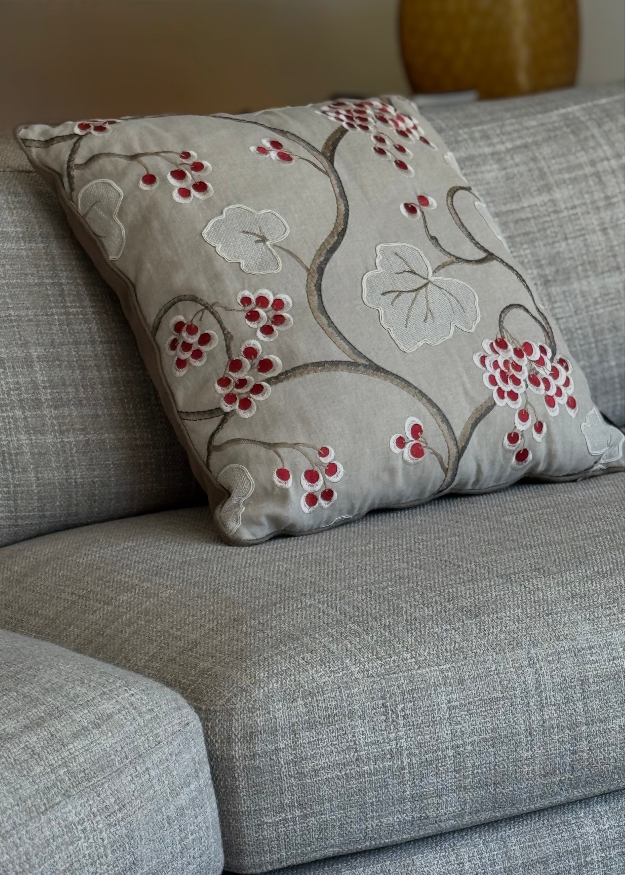 Martin Gabriel deko kissen modell leaf & berry mit floraler stickerei in natur - und beigetönen auf grauem sofa