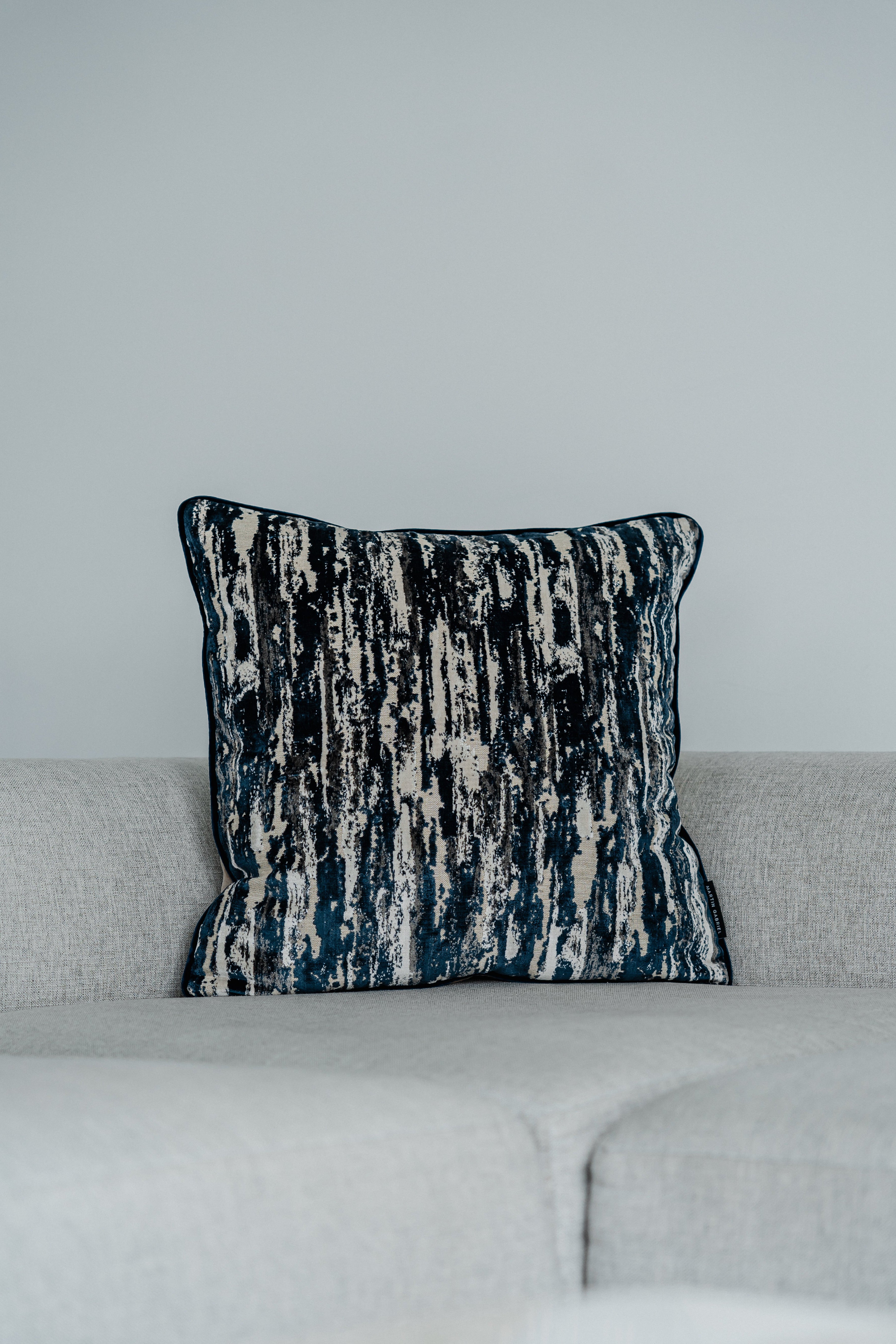 Dekokissen Cascade Blue 60x60 cm auf hellgrauem Sofa – Vorderansicht