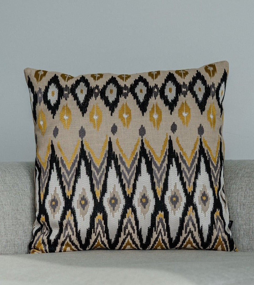 Martin Gabriel designkissen modell Ikato mit karomuster in weiss geld´b und beige besticktes. textil auf hellgrauen sofa 