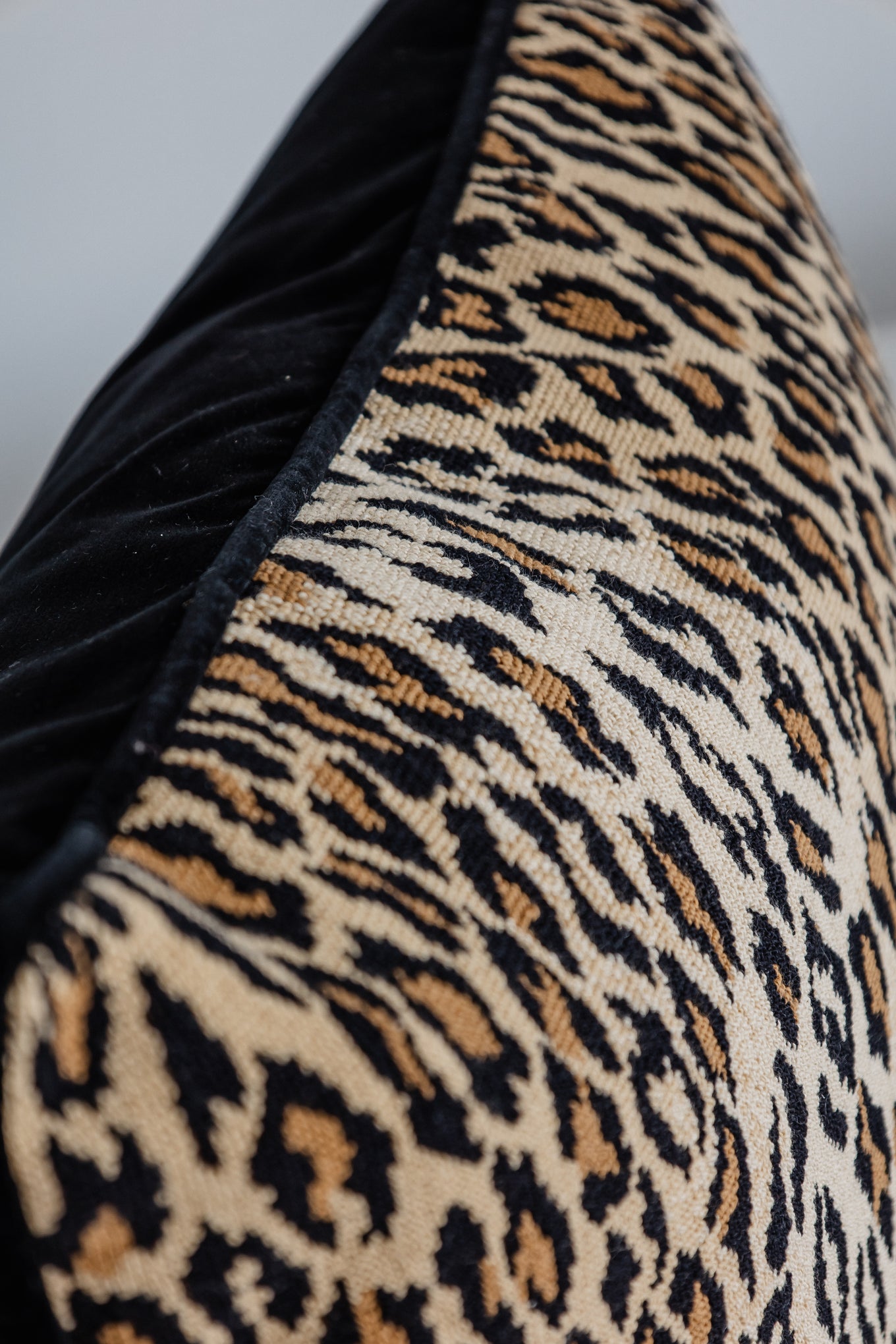 Detailaufnahme Leopard-Print Kissen mit schwarzer Kante, hochwertige Verarbeitung.