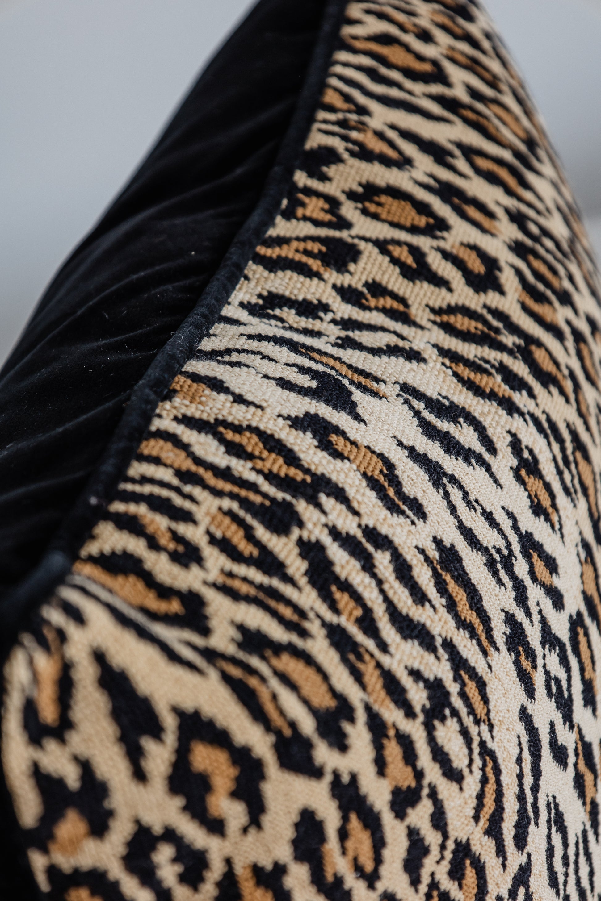 Detailaufnahme Leopard-Print Kissen mit schwarzer Kante, hochwertige Verarbeitung.