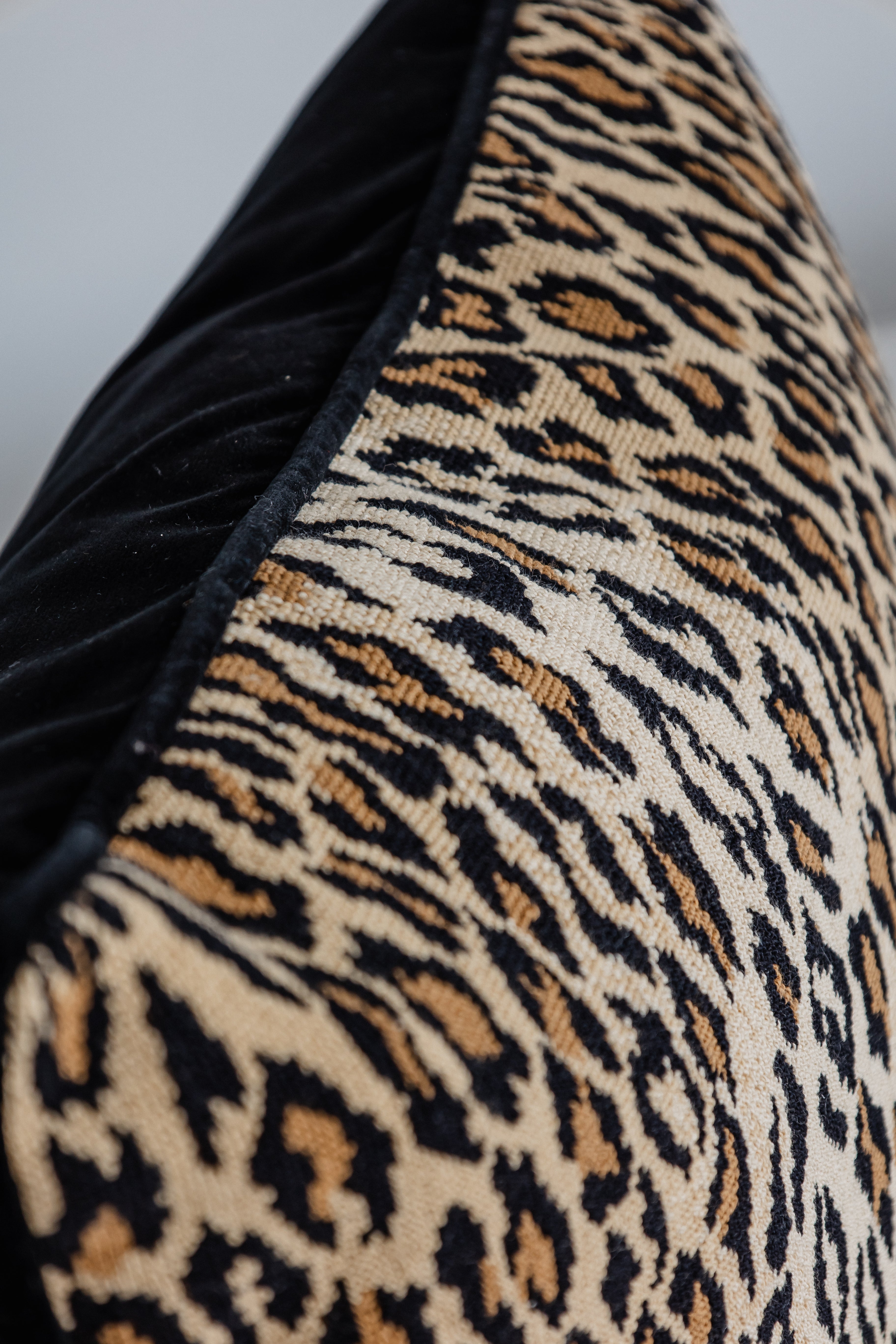 Detailaufnahme Leopard-Print Kissen mit schwarzer Kante, hochwertige Verarbeitung.