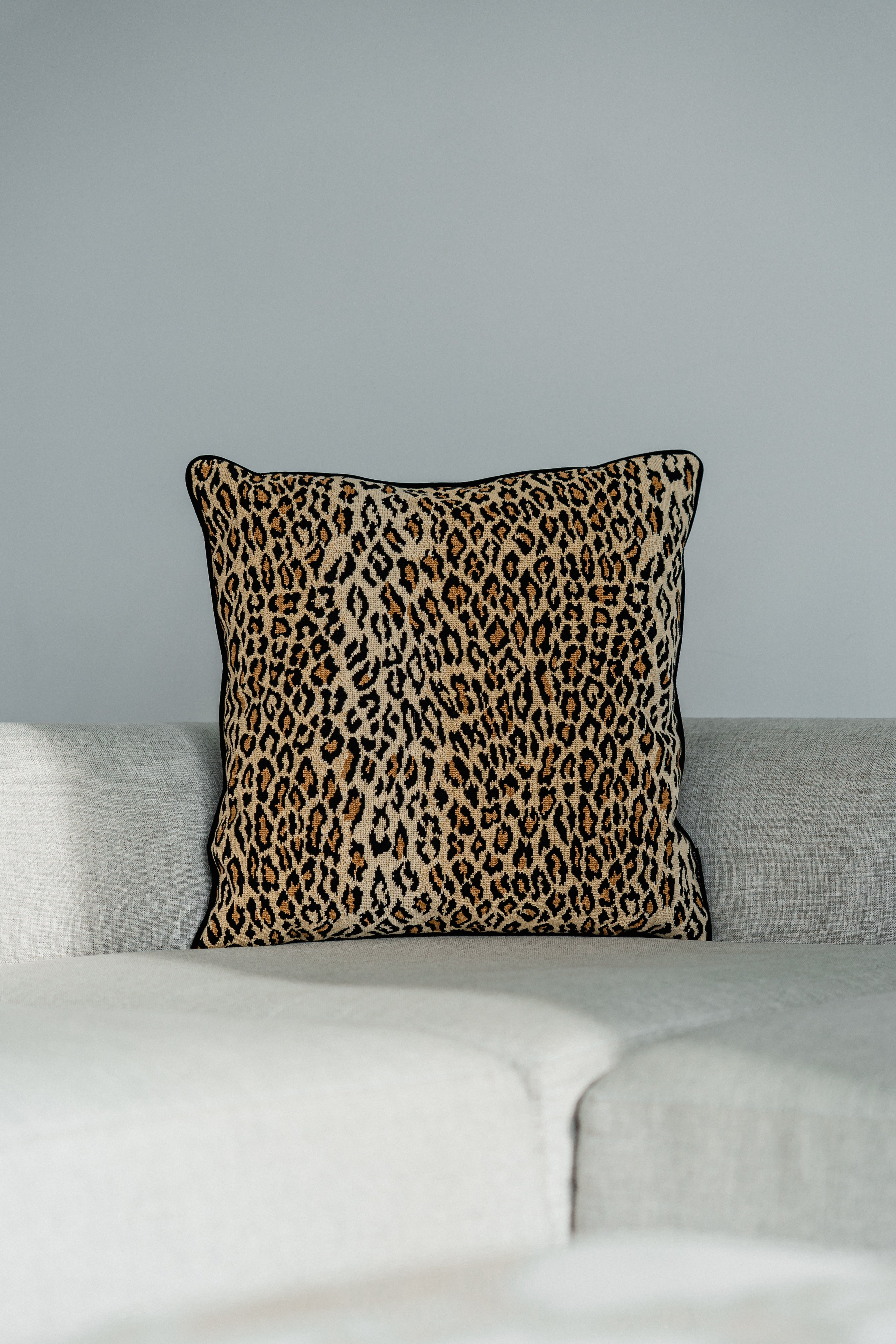 Dekokissen im Leopard-Print, Beige und Schwarz, Designer Kissen auf Sofa.