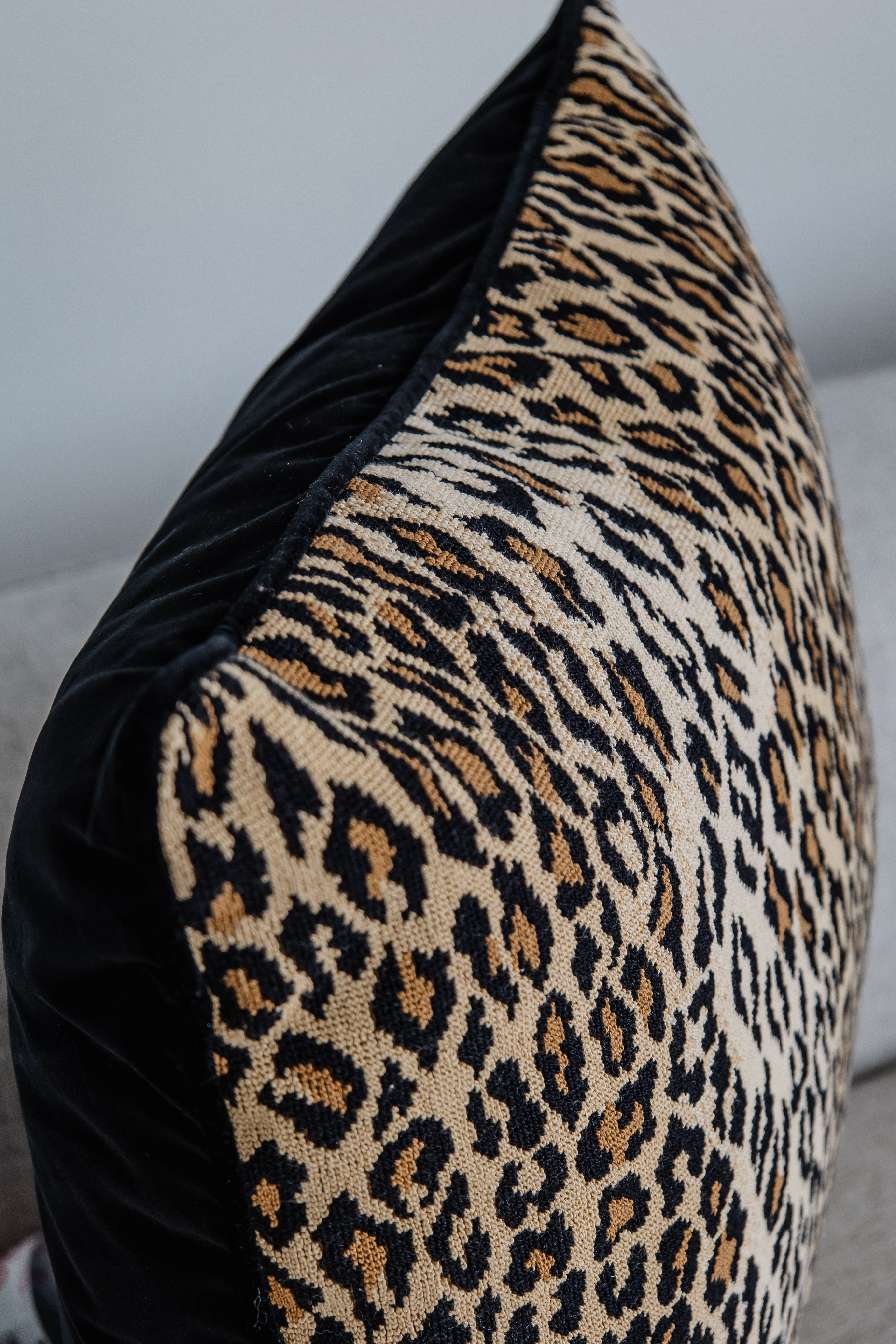 Studioaufnahme Leopard-Kissen auf hellem Sofa, Animal Print in Beige und Schwarz.