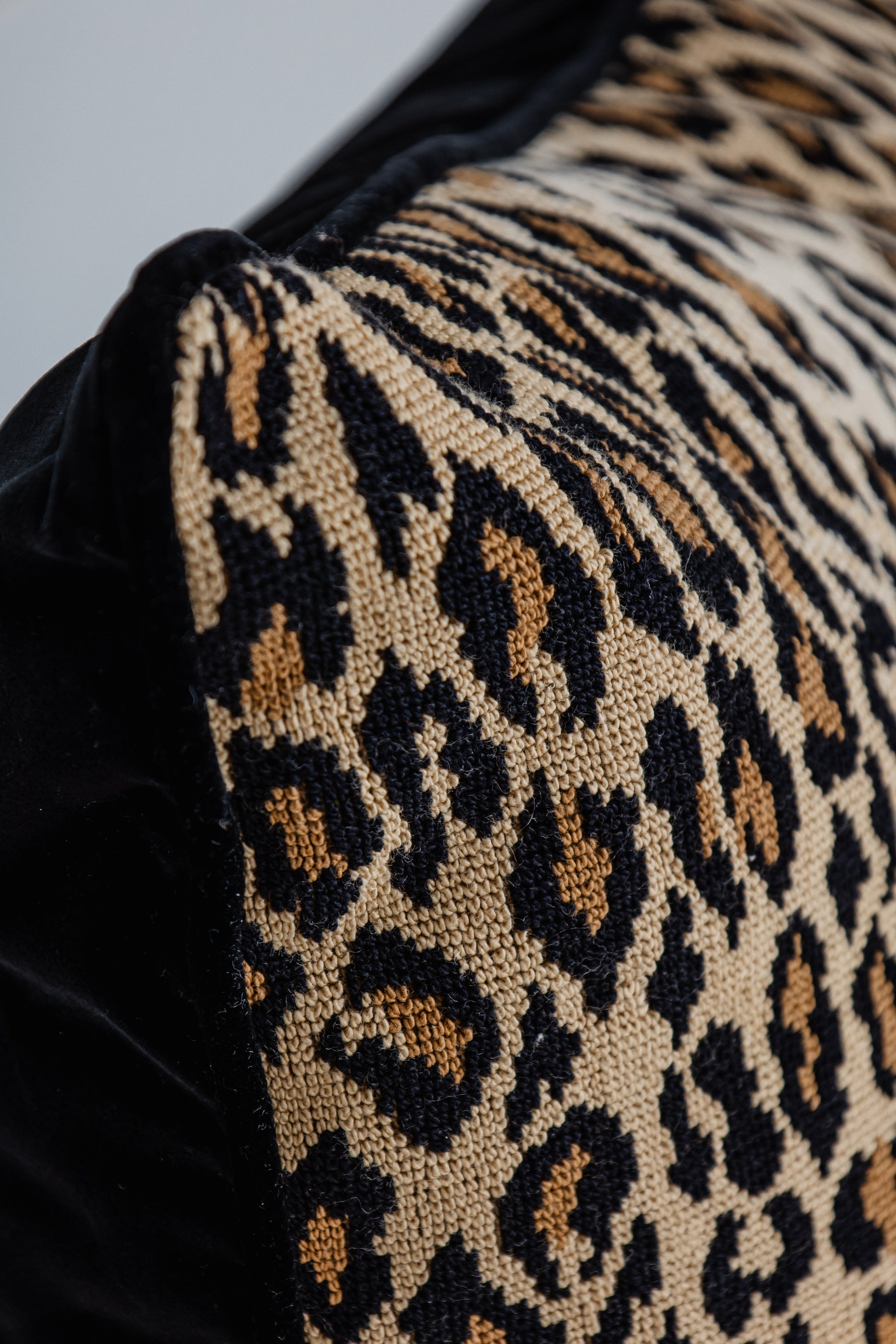 Detailaufnahme Leopard-Print Kissen mit schwarzer Kante, hochwertige Verarbeitung.