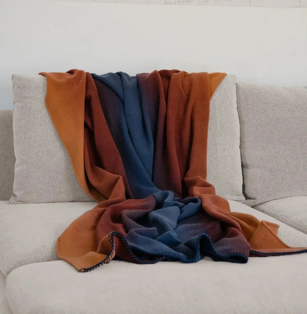 Martin Gabriel Plaid modell Shadow , farbverlauf in der decke von orange bis blau auf sofa 